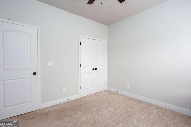 unfurnished bedroom with ceiling fan and light colored carpet