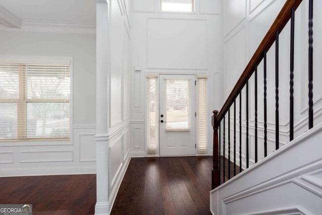 foyer featuring dark hardwood / wood-style flooring, crown molding, and plenty of natural light