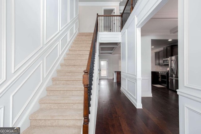 stairs with crown molding and hardwood / wood-style floors