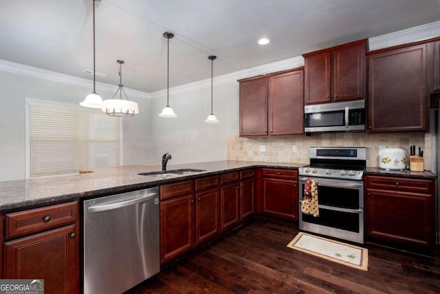 kitchen featuring dark stone counters, sink, decorative light fixtures, kitchen peninsula, and stainless steel appliances