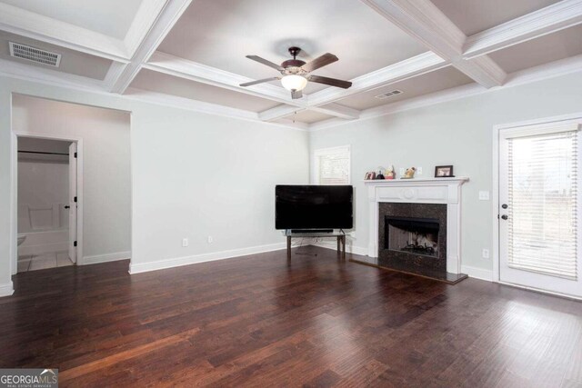 living room with dark wood-type flooring, a high end fireplace, coffered ceiling, ceiling fan, and beam ceiling