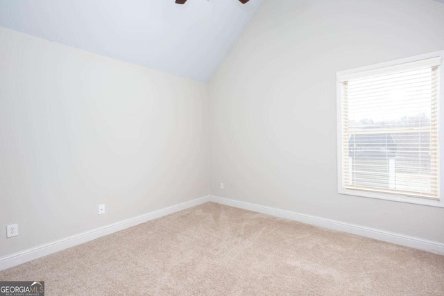 spare room featuring carpet flooring, vaulted ceiling, and ceiling fan