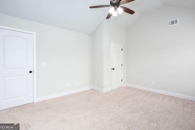 empty room featuring ceiling fan, light carpet, and lofted ceiling