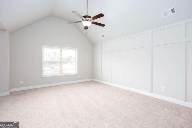 carpeted spare room with vaulted ceiling and ceiling fan