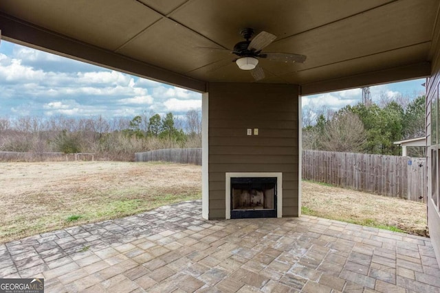 view of patio featuring ceiling fan and a fireplace