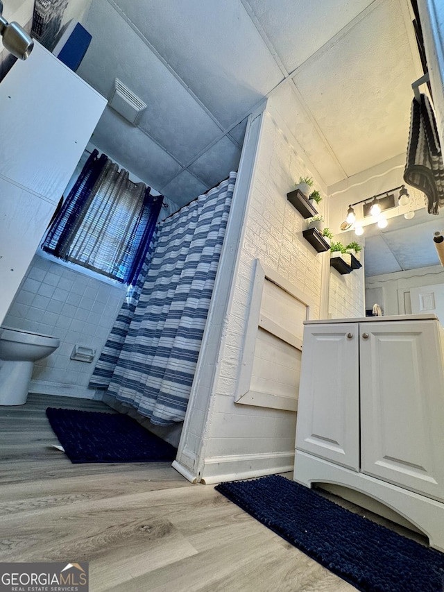 bathroom featuring toilet and wood-type flooring