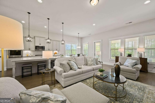 kitchen with built in shelves, a breakfast bar, sink, a center island with sink, and appliances with stainless steel finishes