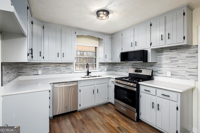 kitchen with a textured ceiling, stainless steel appliances, dark wood-type flooring, and sink