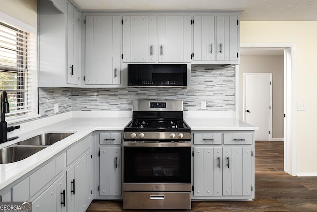 kitchen featuring sink, tasteful backsplash, dark hardwood / wood-style floors, white cabinets, and stainless steel range with gas stovetop