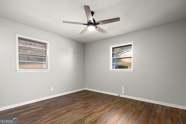 empty room with ceiling fan and dark hardwood / wood-style flooring