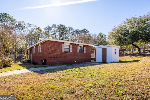 view of front of home featuring central air condition unit, a front lawn, and a storage unit