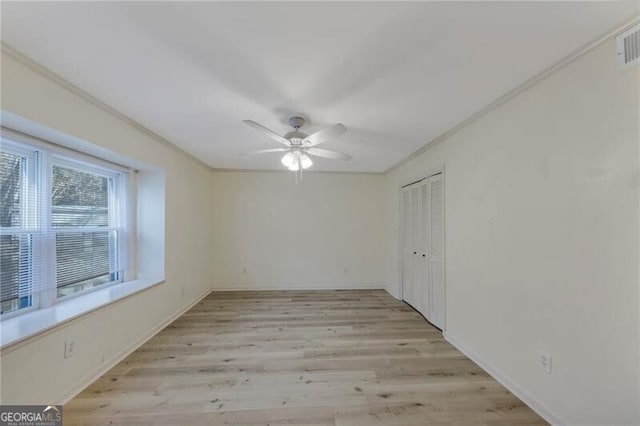 empty room featuring ceiling fan, ornamental molding, and light hardwood / wood-style floors