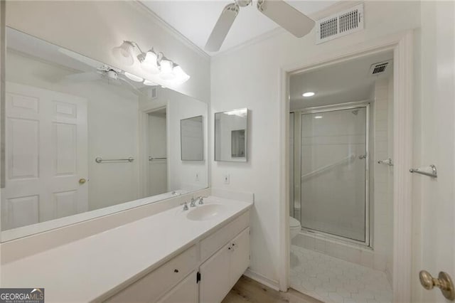 bathroom featuring toilet, crown molding, an enclosed shower, ceiling fan, and vanity