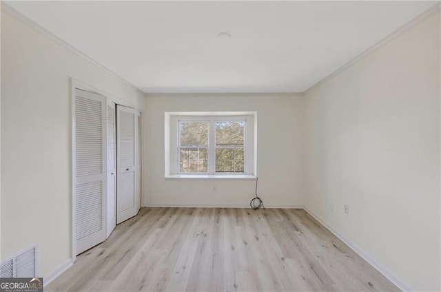 unfurnished bedroom featuring crown molding and light hardwood / wood-style flooring