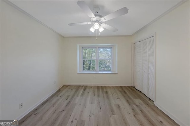 unfurnished bedroom with ceiling fan, light wood-type flooring, a closet, and crown molding