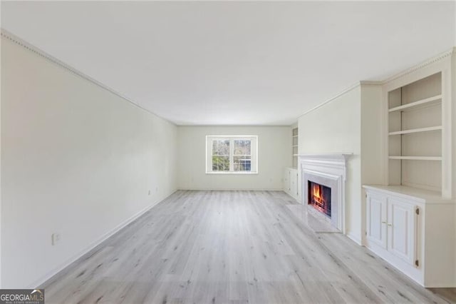 unfurnished living room with light wood-type flooring and built in features