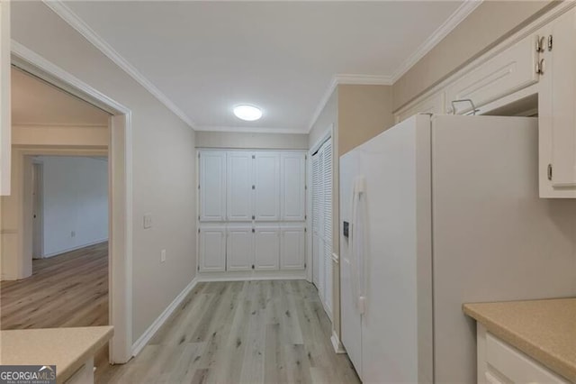 interior space with ornamental molding, white fridge with ice dispenser, light hardwood / wood-style floors, and white cabinetry