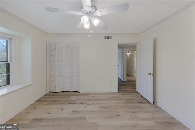 unfurnished bedroom featuring ornamental molding, ceiling fan, light hardwood / wood-style flooring, and a closet