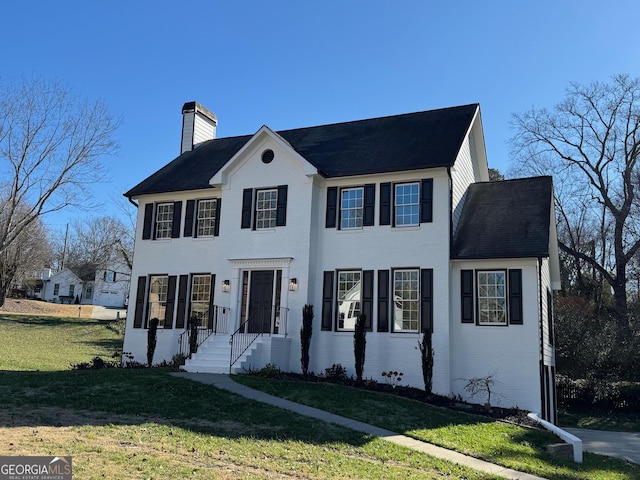 colonial inspired home with a front lawn