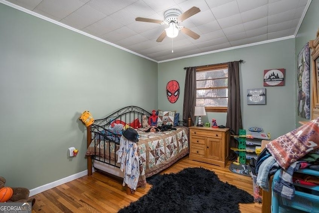 bedroom featuring ceiling fan, crown molding, and light hardwood / wood-style flooring