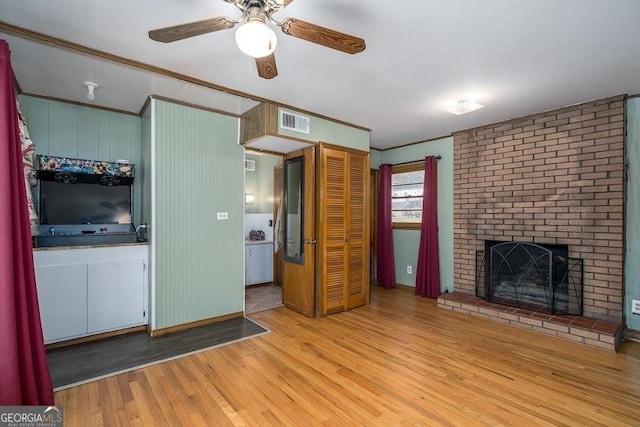 unfurnished living room with ceiling fan, light hardwood / wood-style floors, and a fireplace