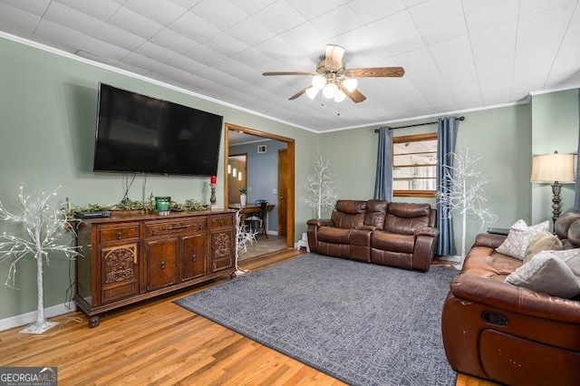 living room featuring ceiling fan, ornamental molding, and hardwood / wood-style flooring