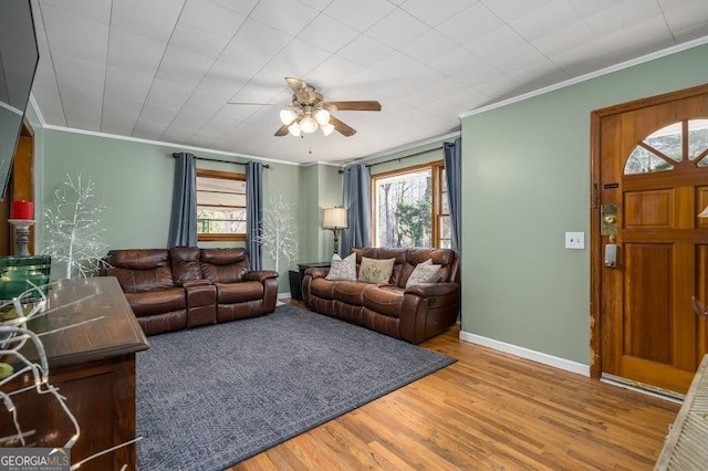 living room with hardwood / wood-style flooring, ceiling fan, and ornamental molding