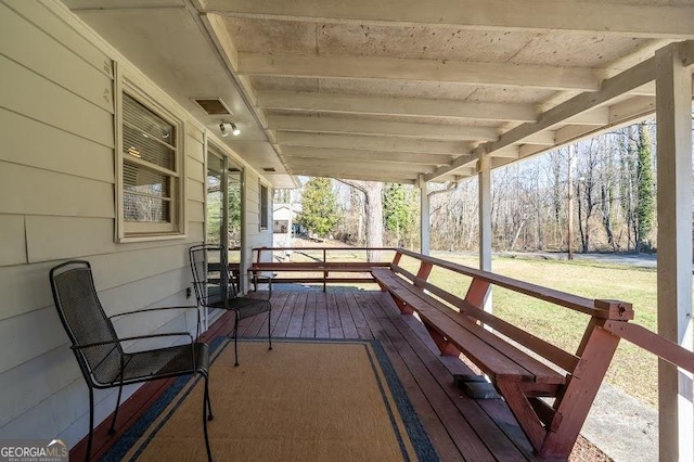 wooden deck featuring a lawn