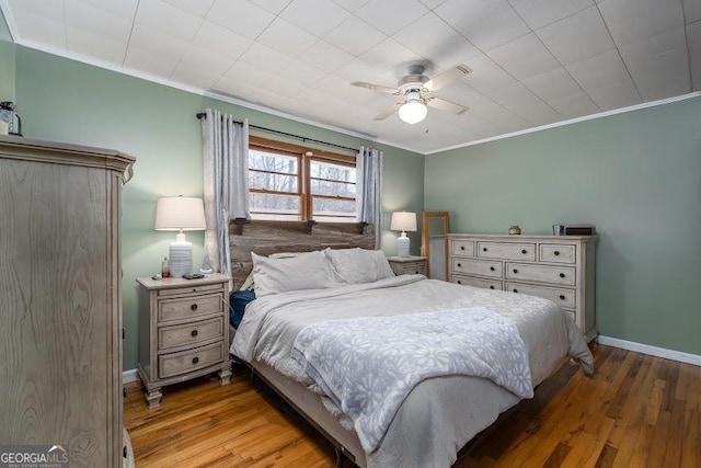 bedroom with light hardwood / wood-style floors, ceiling fan, and ornamental molding