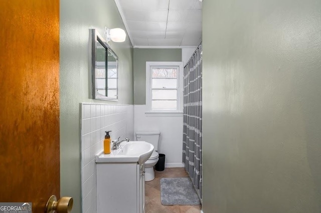 bathroom with vanity, toilet, ornamental molding, and walk in shower