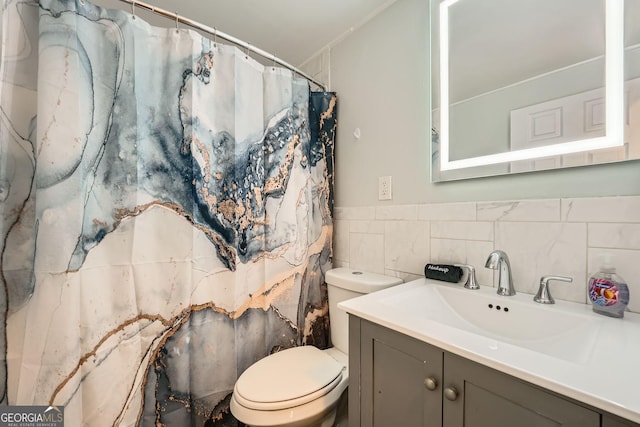 bathroom featuring decorative backsplash, vanity, tile walls, and toilet