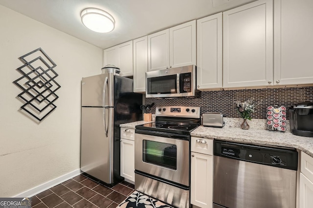 kitchen featuring light stone countertops, appliances with stainless steel finishes, tasteful backsplash, and white cabinetry