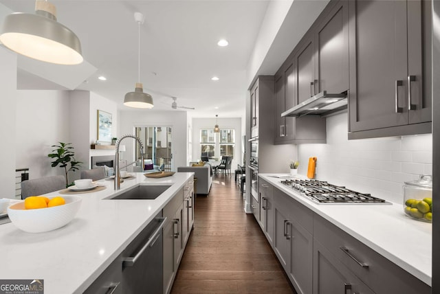 kitchen featuring sink, decorative light fixtures, decorative backsplash, dark hardwood / wood-style flooring, and appliances with stainless steel finishes