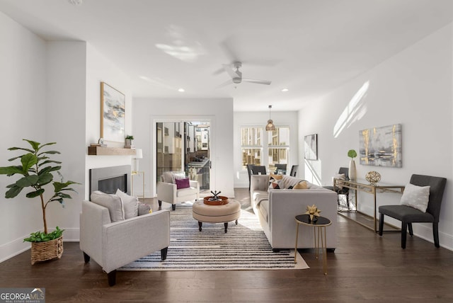 living room featuring ceiling fan and dark hardwood / wood-style flooring