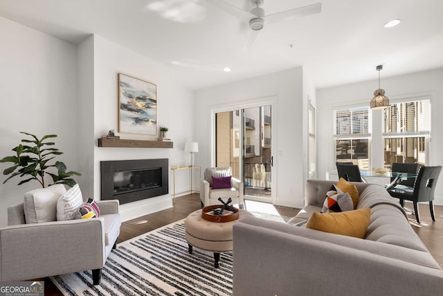 living room featuring ceiling fan and dark hardwood / wood-style flooring