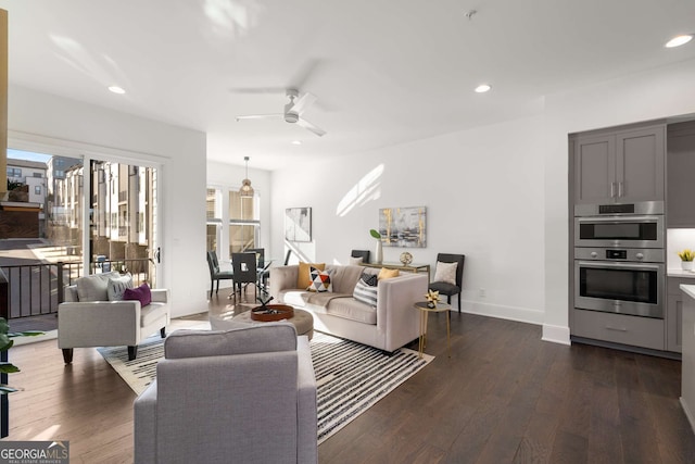 living room featuring ceiling fan and dark hardwood / wood-style floors