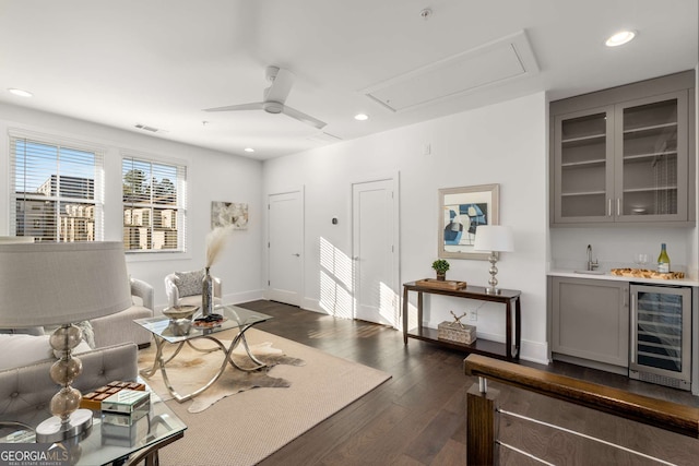 living room featuring bar, beverage cooler, ceiling fan, and dark hardwood / wood-style flooring