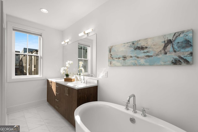 bathroom with a tub and vanity