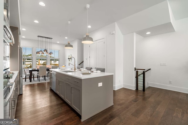 kitchen with sink, dishwasher, hanging light fixtures, a center island with sink, and gray cabinetry