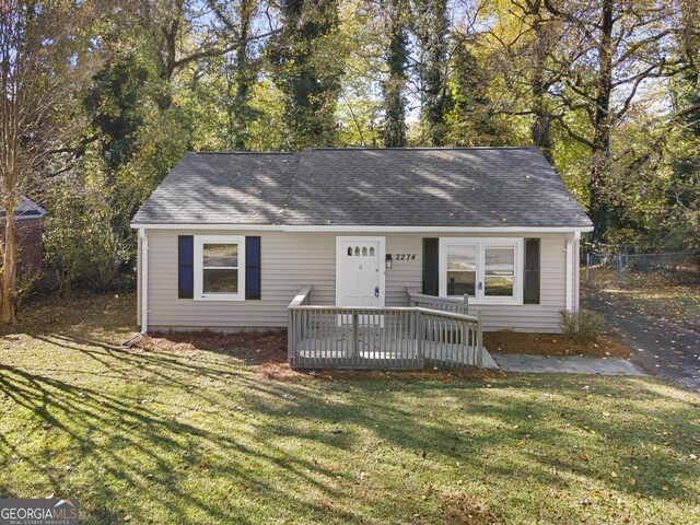 ranch-style house featuring a deck and a front lawn