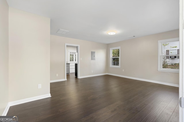 spare room featuring dark hardwood / wood-style flooring and electric panel