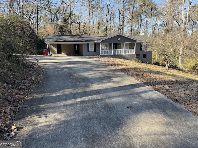 ranch-style home featuring covered porch and a carport