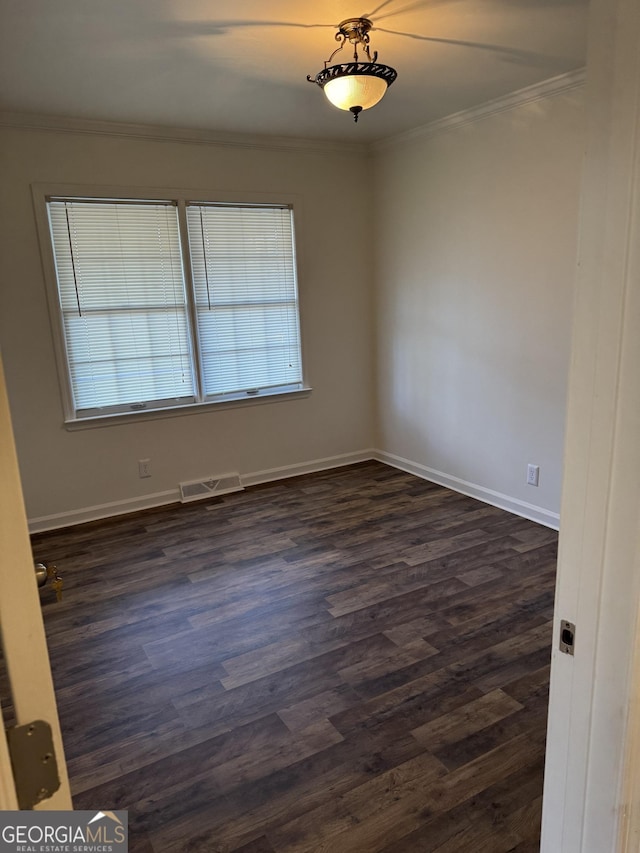 empty room with ornamental molding and dark wood-type flooring