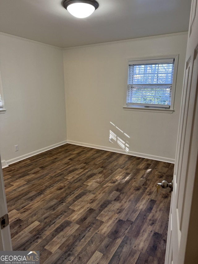 empty room with dark hardwood / wood-style flooring and ornamental molding