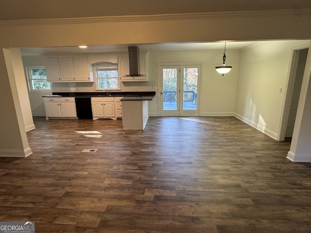 kitchen featuring white cabinetry, dishwasher, wall chimney exhaust hood, plenty of natural light, and pendant lighting