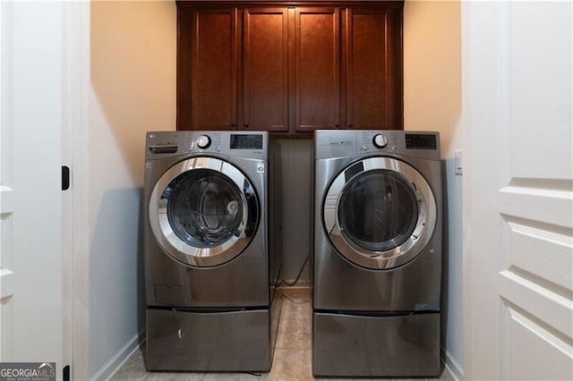 washroom with cabinets and washing machine and dryer