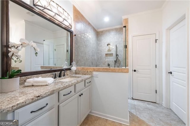 bathroom with vanity, ornamental molding, and tiled shower