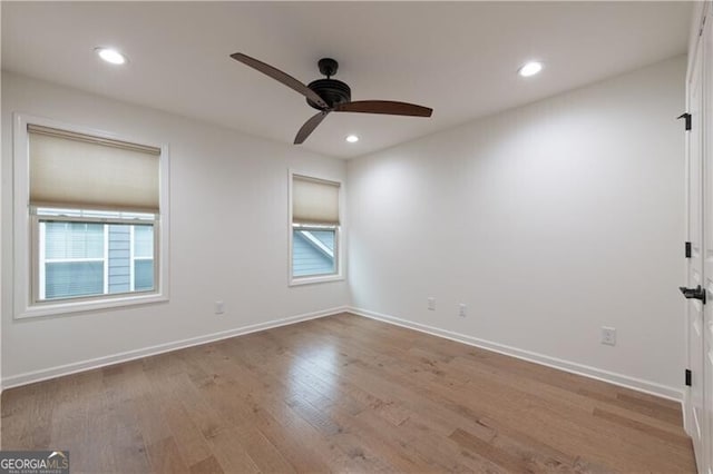 spare room featuring light hardwood / wood-style flooring, a wealth of natural light, and ceiling fan