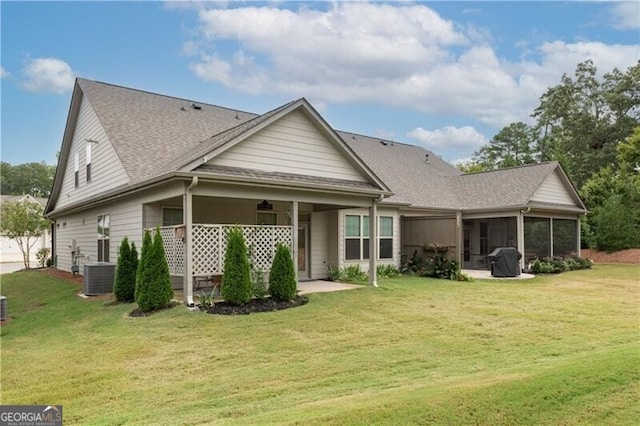 back of property featuring a lawn, a patio area, and a sunroom