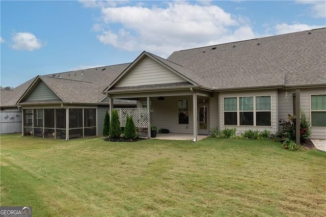 back of property featuring a lawn, a sunroom, and a patio